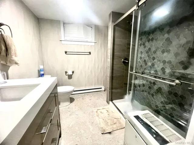 a bathroom with a granite countertop sink a toilet and shower