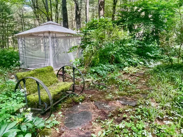 a view of a garden with a bench under an umbrella