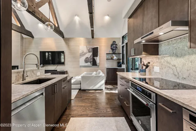 a dining room with furniture a chandelier and wooden floor