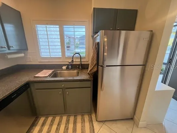 a kitchen with metallic refrigerator and sink