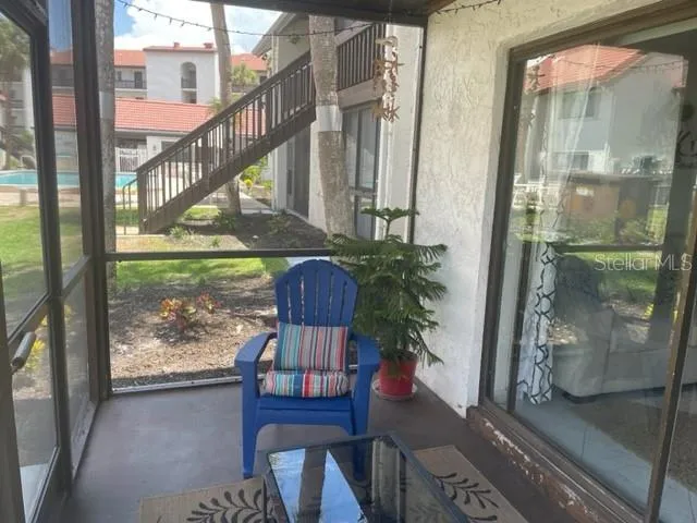 a porch with chairs and potted plants