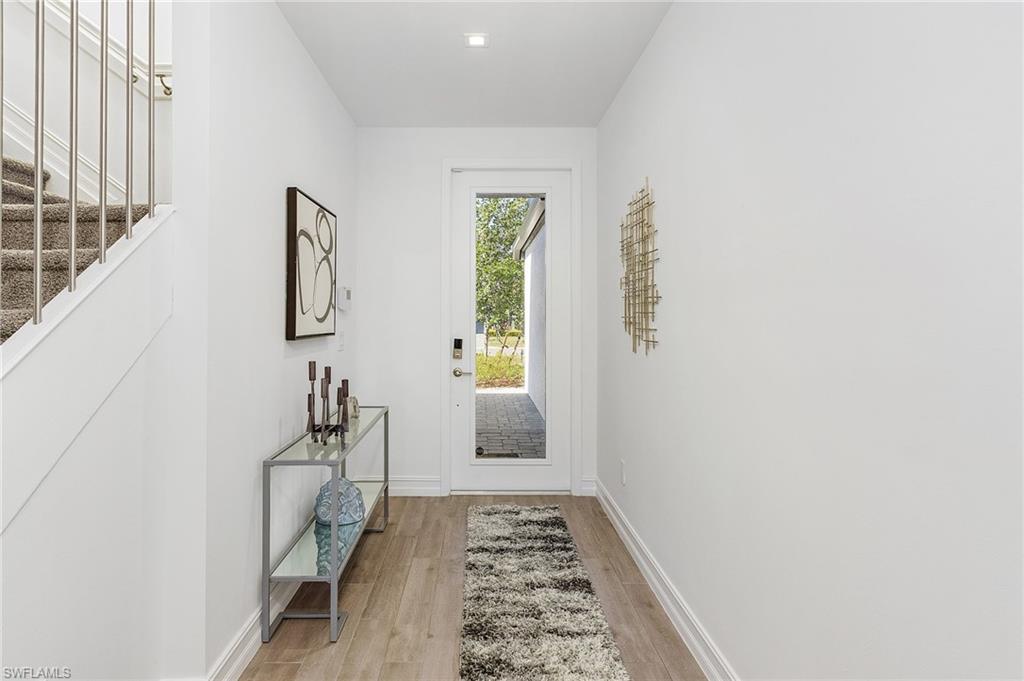 7596 Morgan Way Naples, FL 34119 - Photo 2 of 35 a hallway with a white walls and a window
