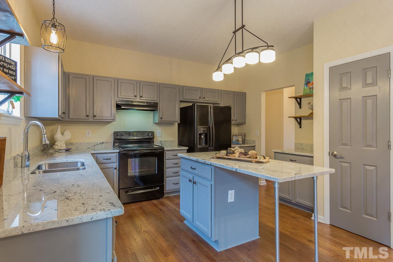12516 Garden Tree Lane Raleigh, NC 27614 - Photo 2 of 25 a kitchen with kitchen island granite countertop a sink stove and refrigerator
