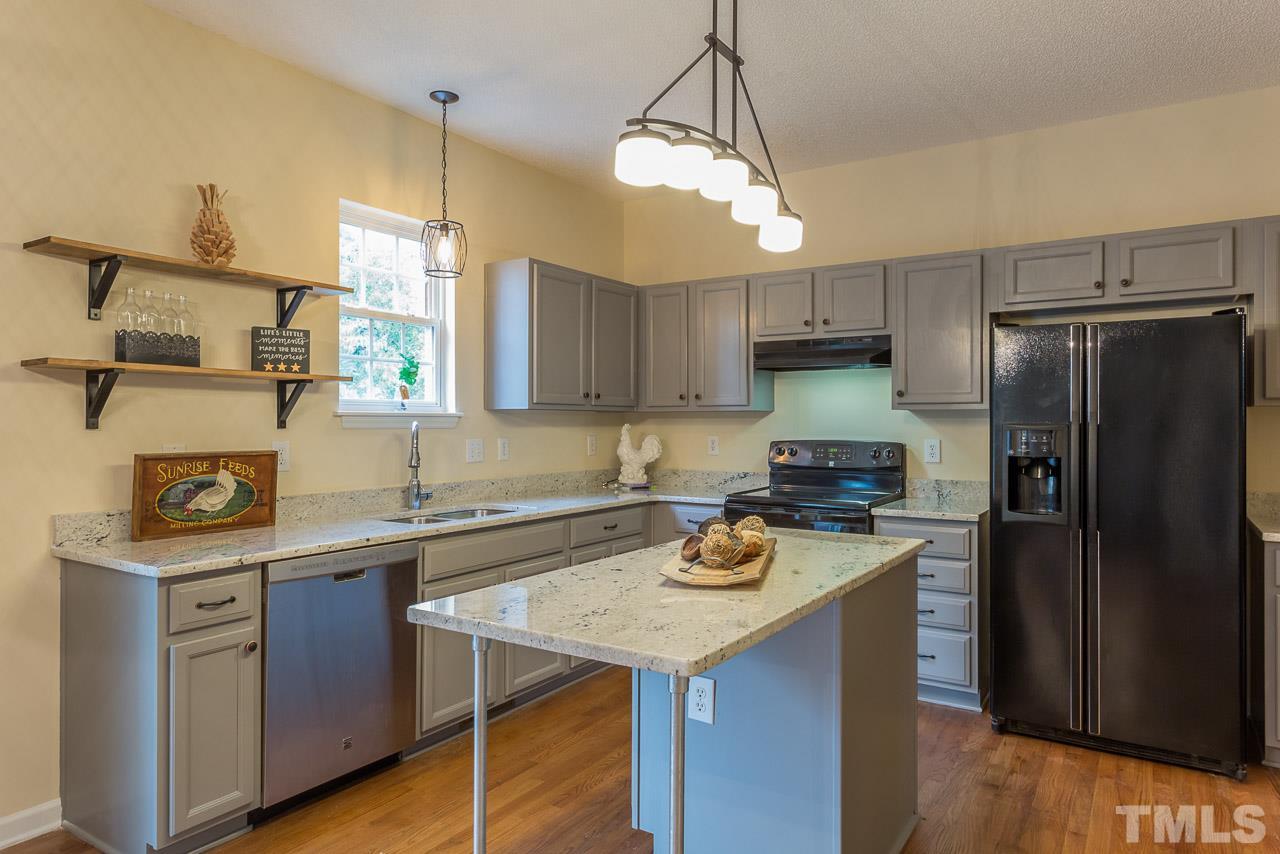12516 Garden Tree Lane Raleigh, NC 27614 - Photo 10 of 25 a kitchen with a refrigerator a stove a sink and a center island