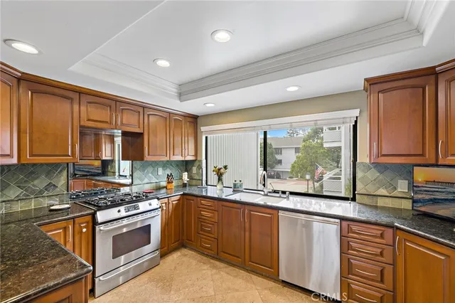 a kitchen with stainless steel appliances granite countertop a sink stove and cabinets