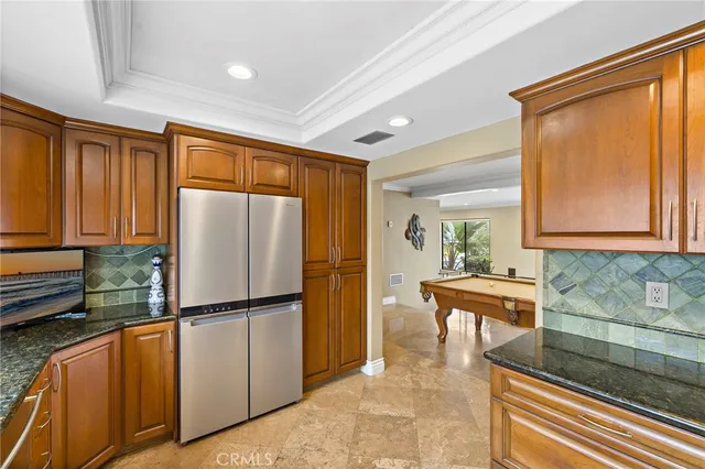 a kitchen with stainless steel appliances granite countertop a refrigerator and a sink