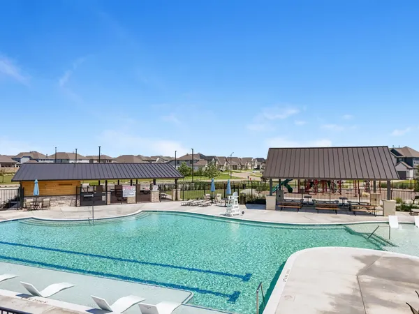 a view of a swimming pool with a garden and seating area