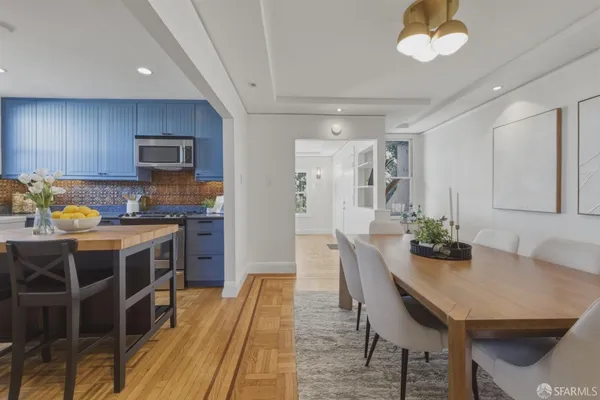 a kitchen with stainless steel appliances a dining table chairs and granite counter tops