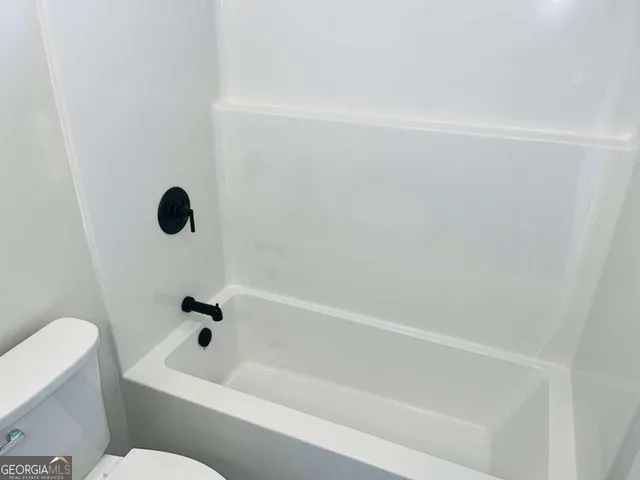 a bathroom with a bathtub and a toilet