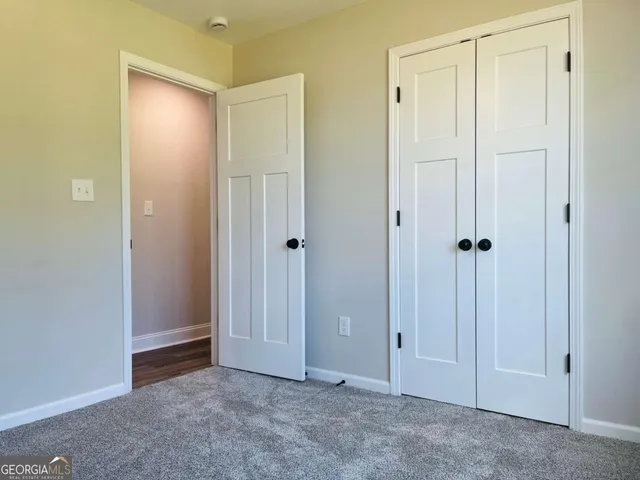 a view of an empty room with closet area