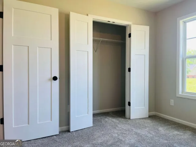 an empty room with windows and closet