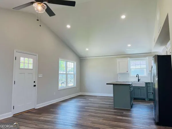 a view of an empty room with a window and wooden floor