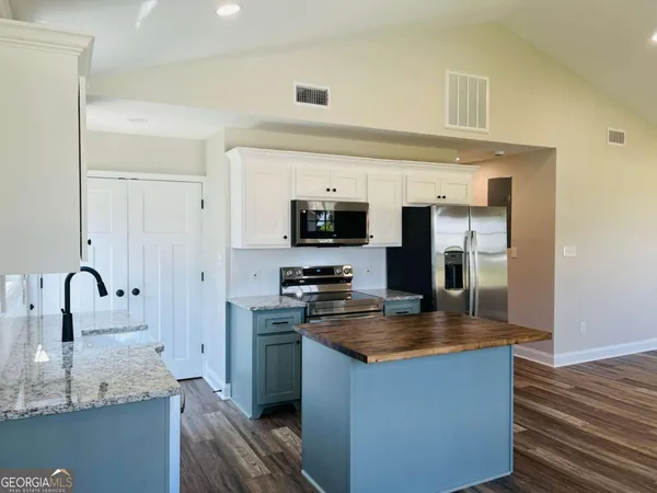 a kitchen with granite countertop a sink stove and refrigerator