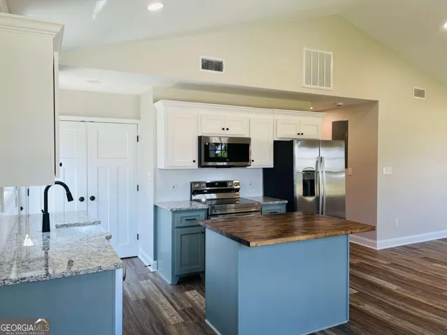a kitchen with granite countertop a sink stove and refrigerator