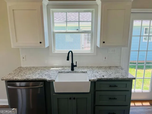 a kitchen with stainless steel appliances granite countertop a sink stove and cabinets