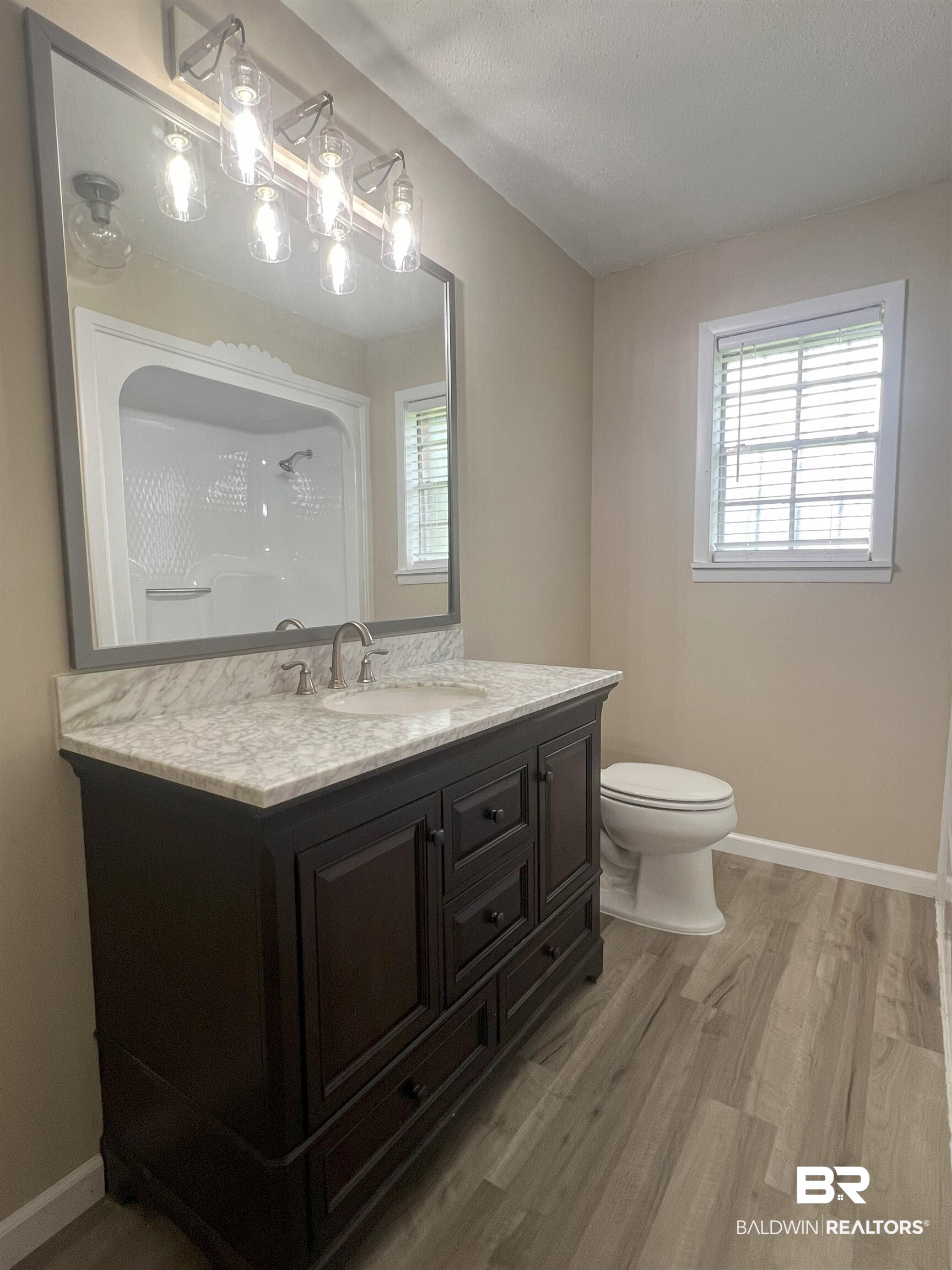 508 Freemanville Drive Atmore, AL 36502 - Photo 16 of 27 Bathroom featuring vanity, hardwood / wood-style flooring, and toilet