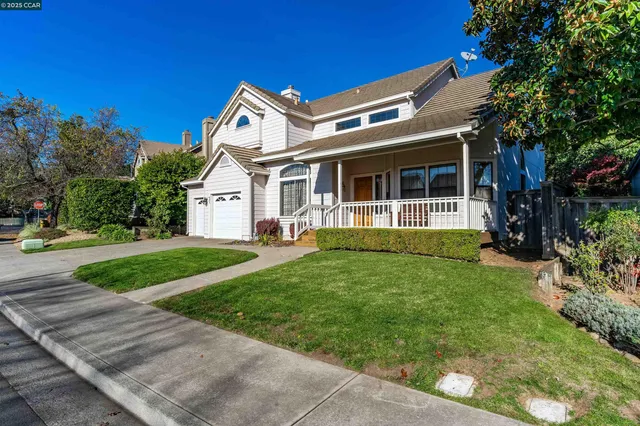 a front view of a house with a yard and potted plants