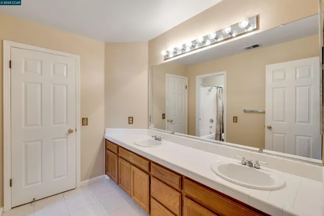 a bedroom with a bed and a lamp on the dresser