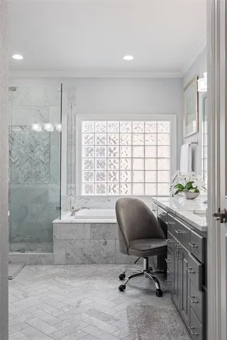 a bathroom with a granite countertop double vanity sink a mirror and a bathtub