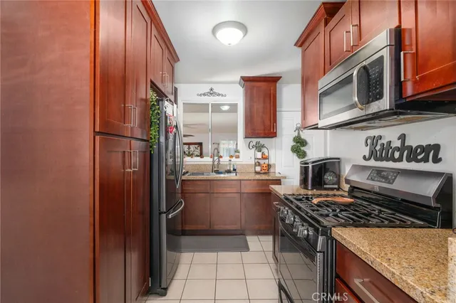 a kitchen with stainless steel appliances granite countertop a stove top oven a sink and dishwasher