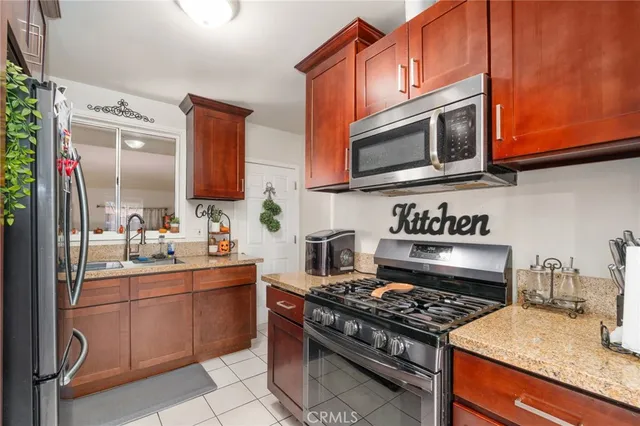 a kitchen with stainless steel appliances granite countertop a stove top oven a sink dishwasher and cabinets with wooden floor