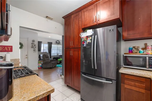 a kitchen with stainless steel appliances granite countertop a refrigerator and a stove