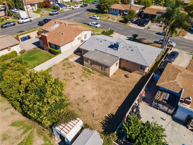 an aerial view of residential houses with outdoor space and parking