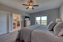 1309 Ridge Pointe Way Blairsville, GA 30512 - Photo 13 of 73 a bedroom with a large bed a chandelier and a flat tv