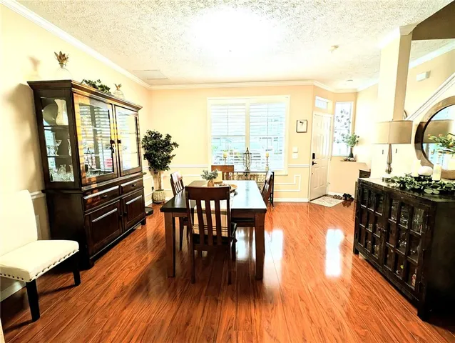 a living room with couches chairs and kitchen view with wooden floor