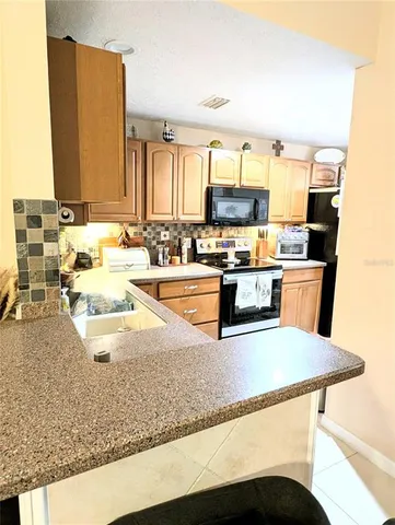 a kitchen with stainless steel appliances granite countertop a sink stove and a refrigerator