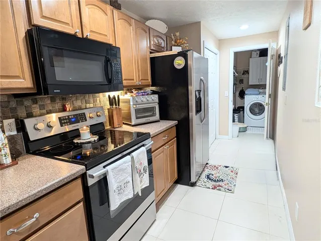 a kitchen with stainless steel appliances a stove microwave and refrigerator
