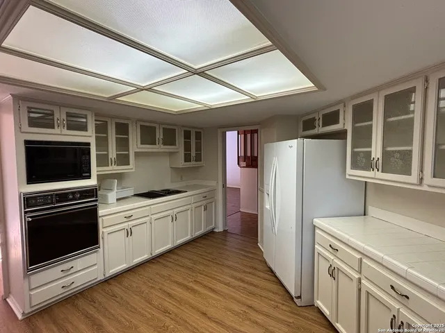 a kitchen with stainless steel appliances granite countertop a refrigerator and a stove top oven