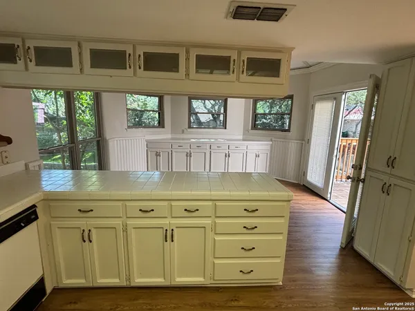 a kitchen with cabinets and wooden floor