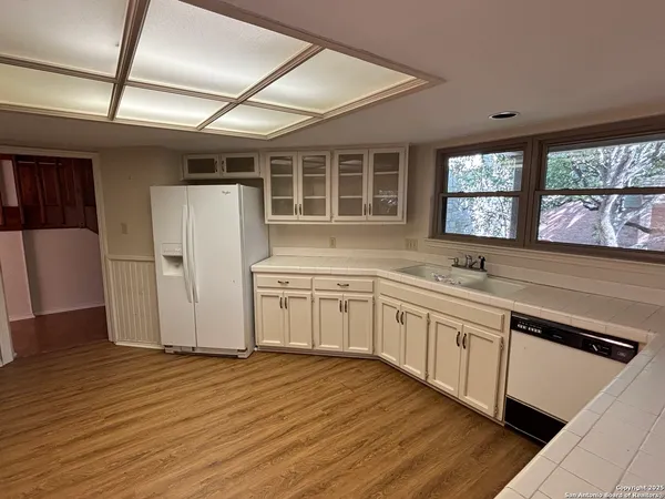 a kitchen with a sink and wooden floor