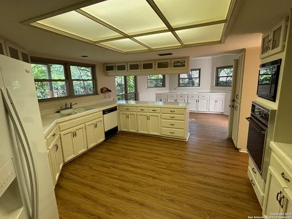 a large kitchen with stainless steel appliances granite countertop a stove and cabinets