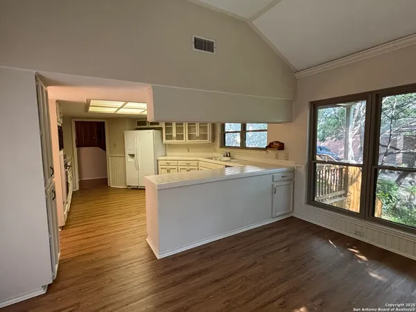 a view of a kitchen with a sink and wooden floor