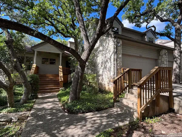 a view of a house with a tree next to a yard