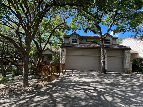 a front view of a house with a tree