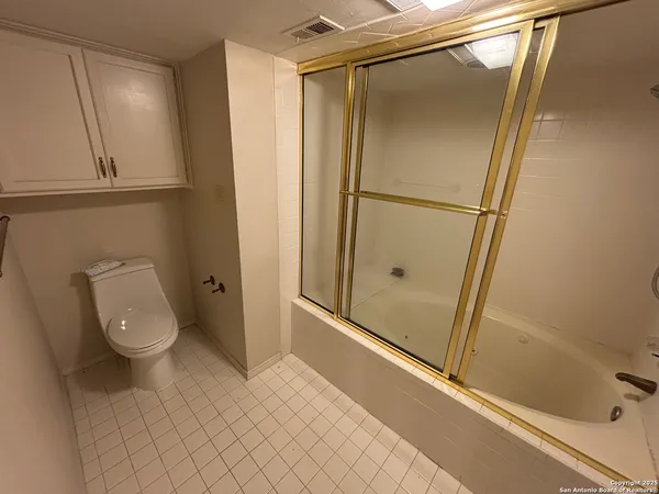 a bathroom with a granite countertop shower and a toilet