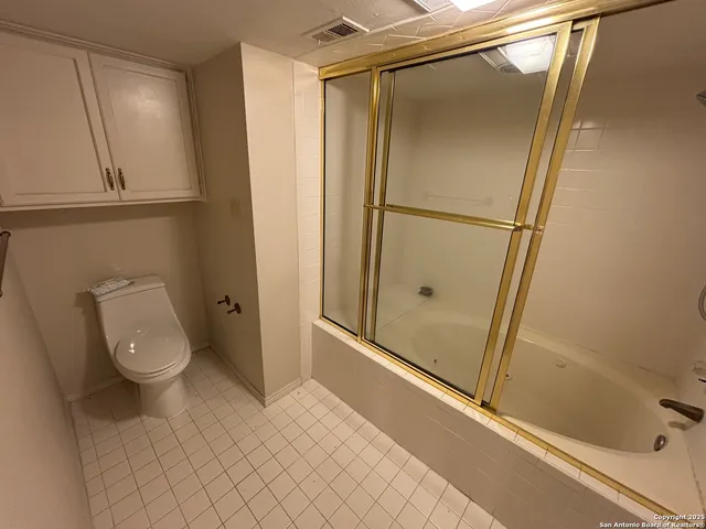a bathroom with a granite countertop shower and a toilet