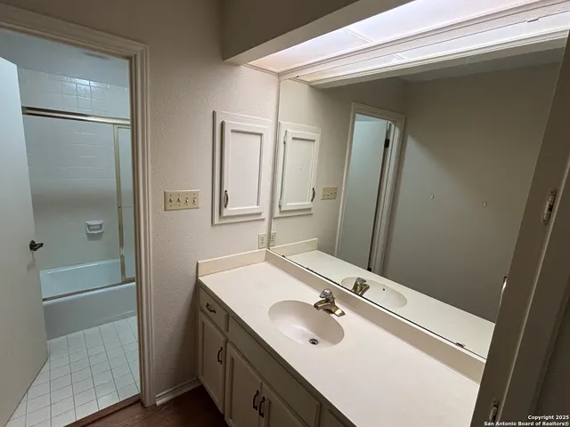 a bathroom with a sink a mirror and a shower