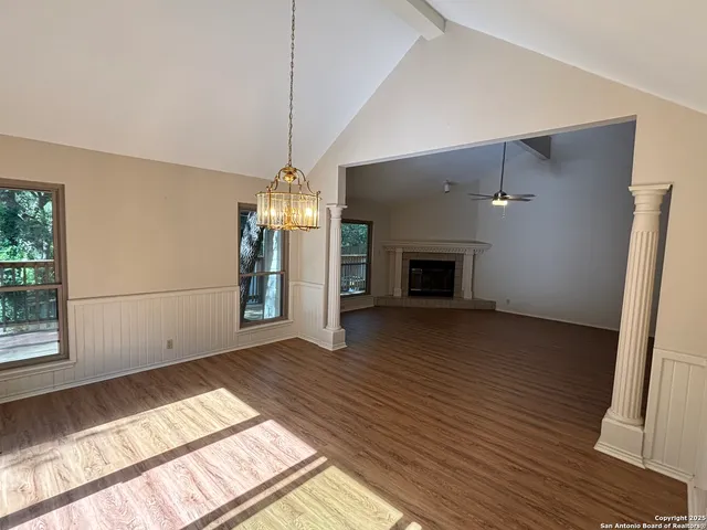 a view of empty room with wooden floor and fireplace