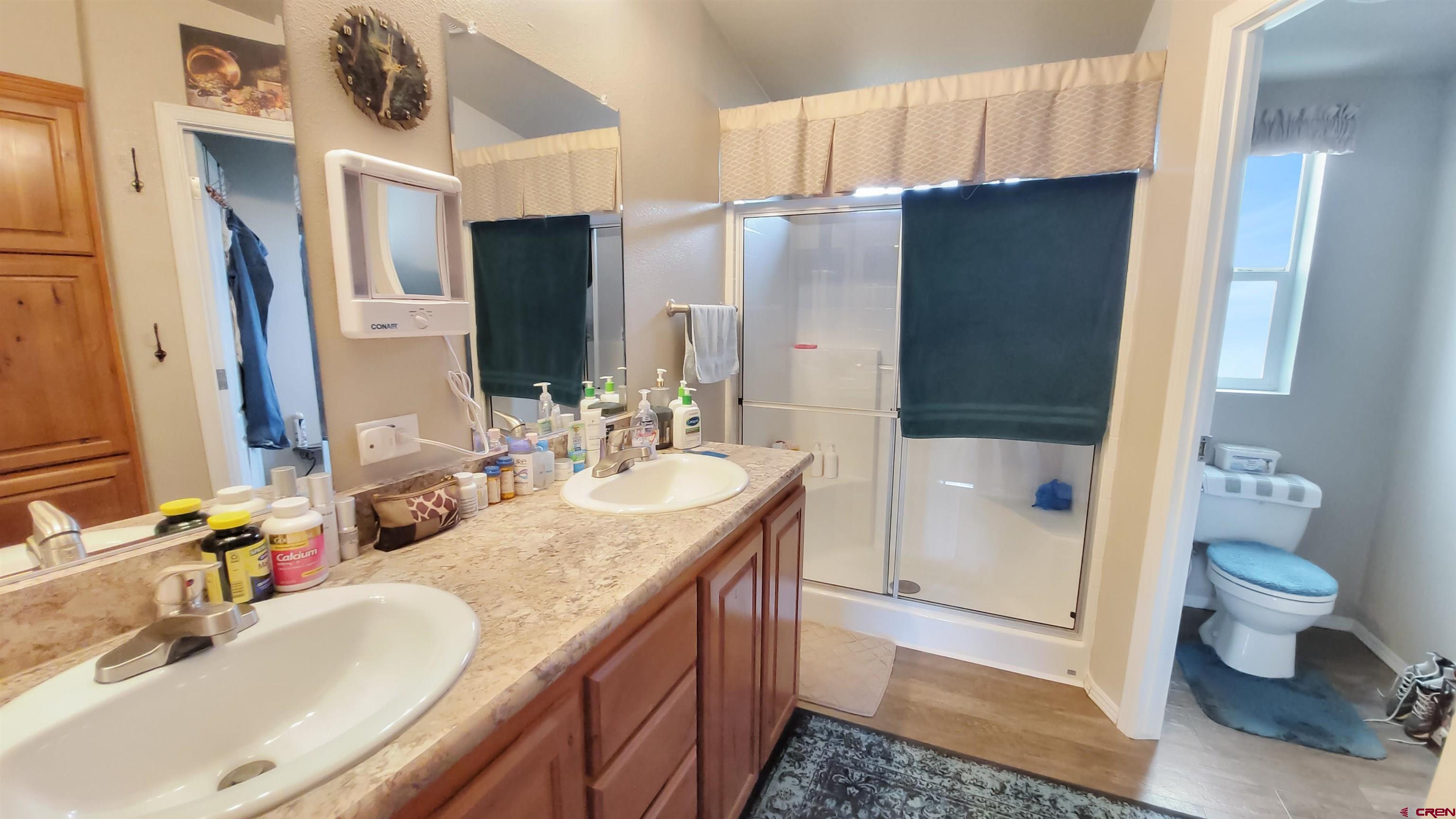 13635 County Road 23 Cortez, CO 81321 - Photo 17 of 30 a bathroom with a granite countertop double vanity sink toilet and shower