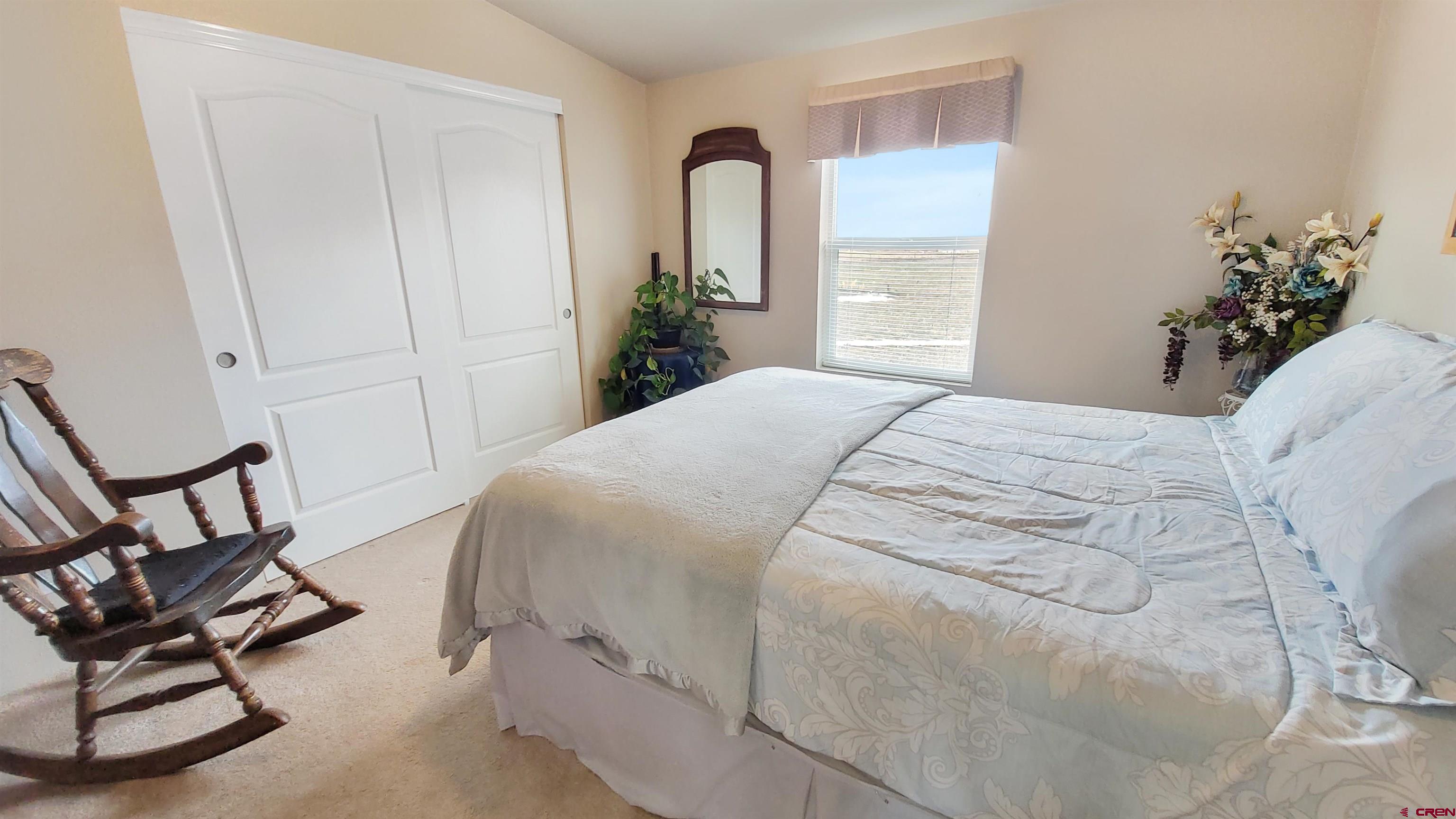 13635 County Road 23 Cortez, CO 81321 - Photo 18 of 30 a bedroom with a bed and a chair