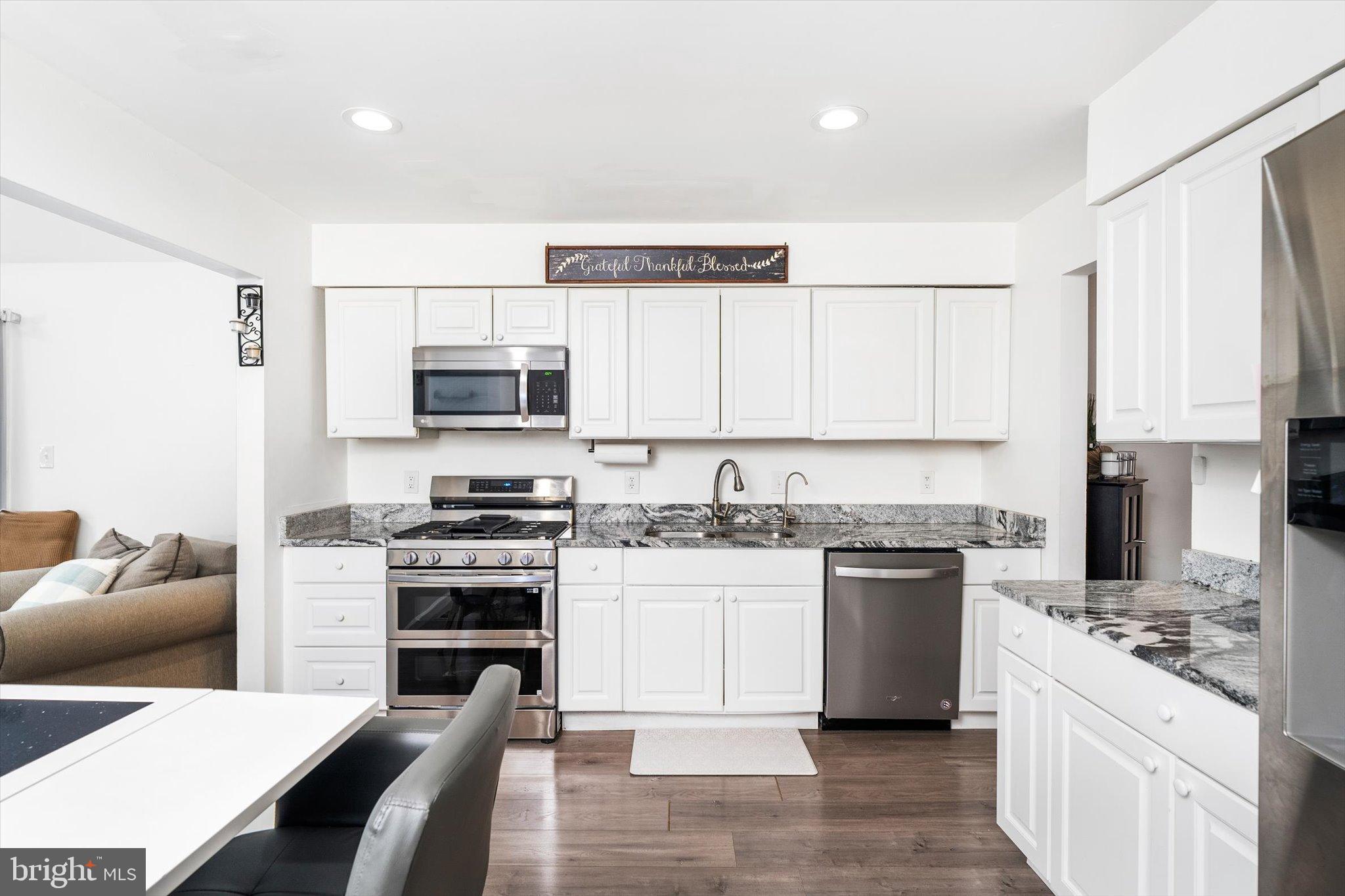 3 Scenic View Drive Sicklerville, NJ 08081 - Photo 6 of 26 a kitchen with stainless steel appliances granite countertop a stove top oven a sink dishwasher and a refrigerator with wooden floor