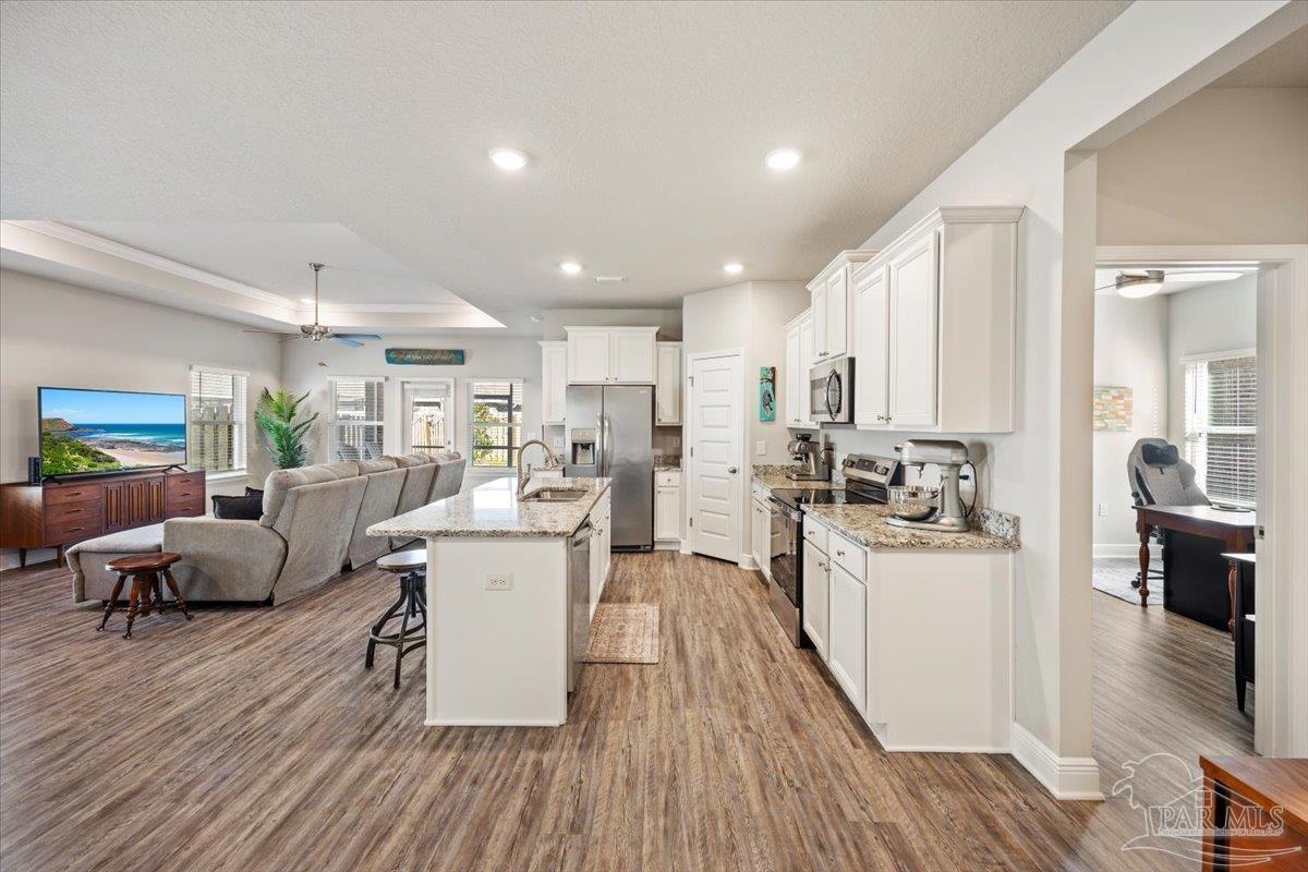 5344 Red Shoulder Road Pace, FL 32571 - Photo 13 of 28 a living room with stainless steel appliances furniture wooden floor and a kitchen view