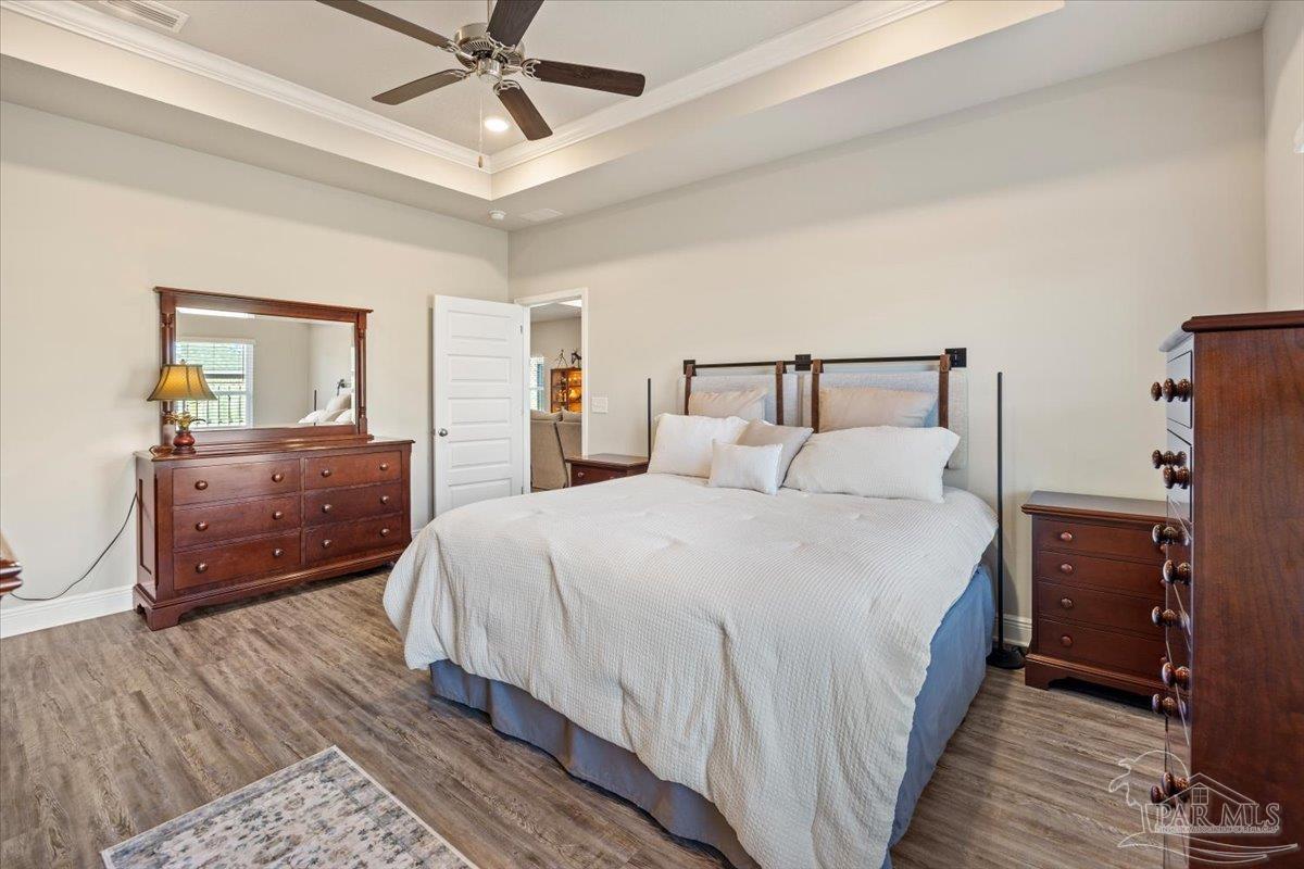 5344 Red Shoulder Road Pace, FL 32571 - Photo 15 of 28 a bedroom with a bed and wooden floor
