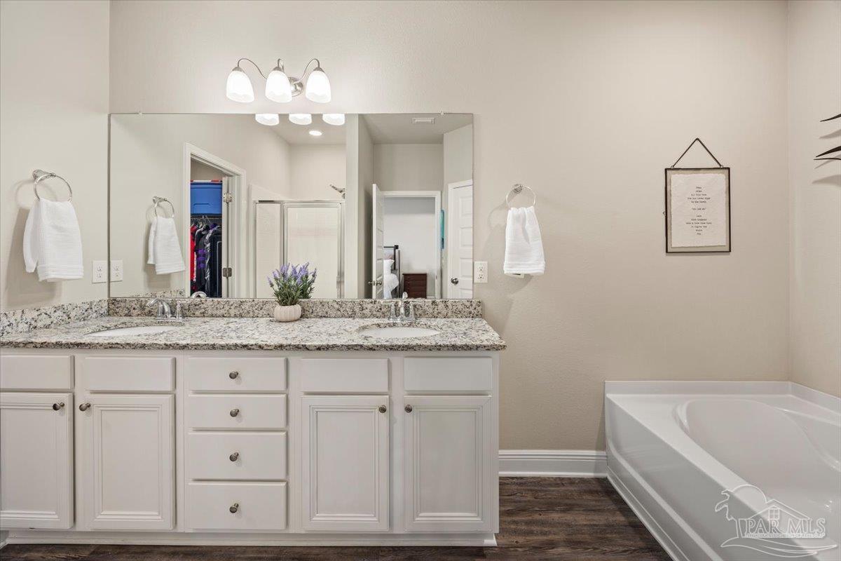 5344 Red Shoulder Road Pace, FL 32571 - Photo 20 of 28 a bathroom with a granite countertop sink a large mirror and a bathtub