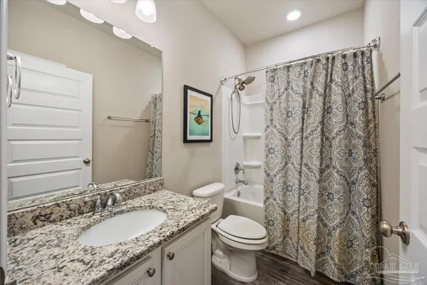 a bathroom with a granite countertop sink toilet and shower