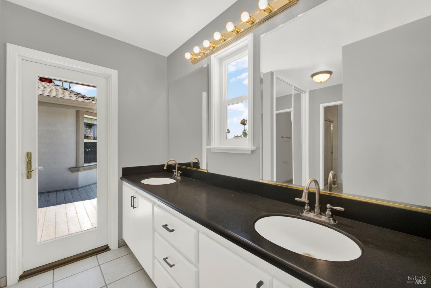 1270 Willow Lake Road Discovery Bay, CA 94505 - Photo 25 of 29 a bathroom with a granite countertop sink and a mirror